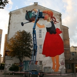 Dziewczynka podlewa drzewo konewką. Oryginalny mural w centrum